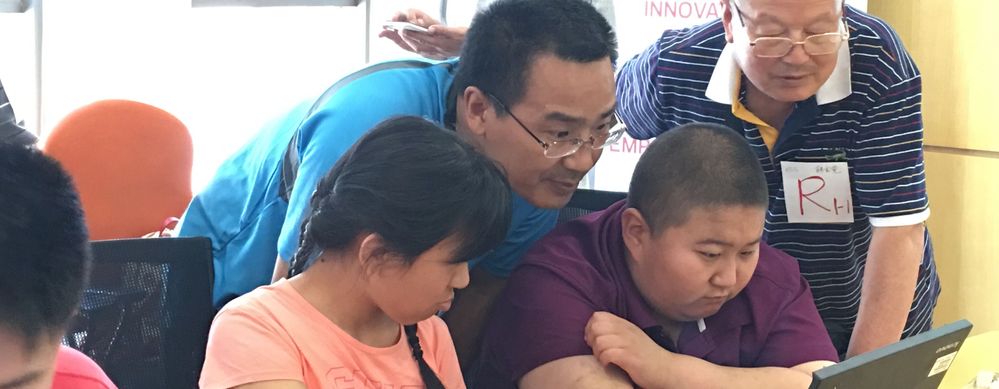 The Beijing team developed an accessible, engaging computer science-focused workshop for students of RARL. Here, two students share the programming experience with Xing Hui, Veritas staff, and the grandfather of one student.