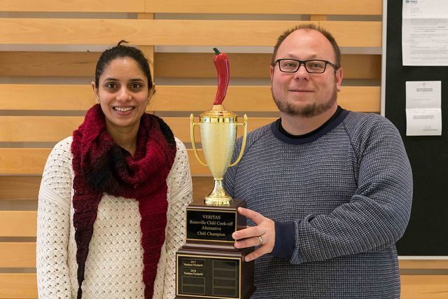 Two winners of the annual chili cook-off, proudly hold the event trophy.